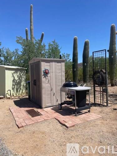 A portable toilet is placed on a brick platform in a desert-like environment.