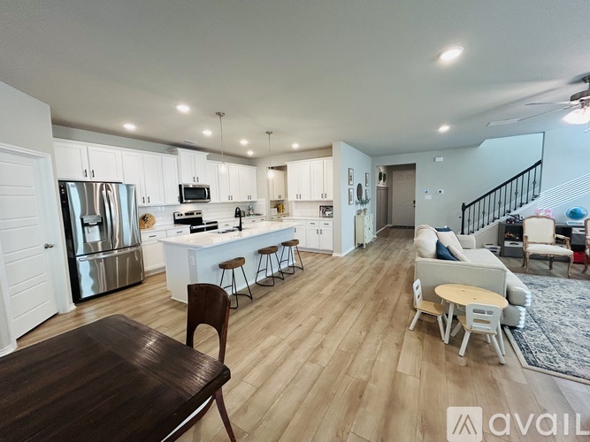 A modern kitchen with white cabinets and a wooden table.
