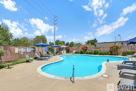 A pool with a blue umbrella and chairs around it.