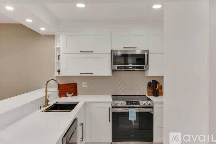 A modern kitchen with a stainless steel oven and white cabinets.