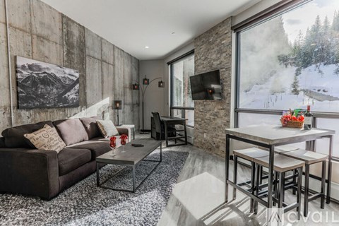 A living room with a couch, a coffee table, and a television.