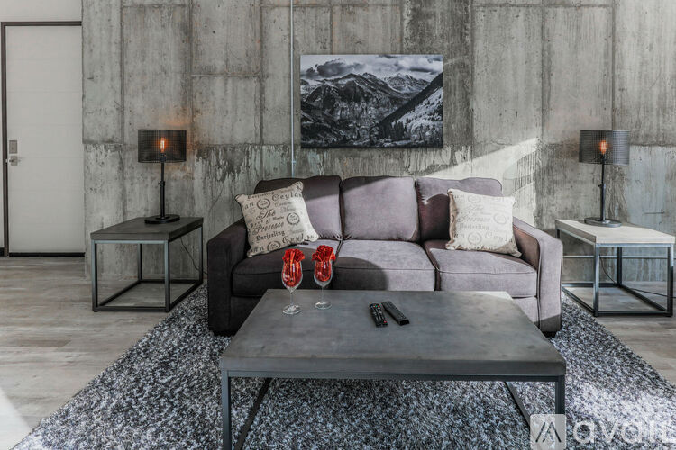 A grey couch with a coffee table in front of it.