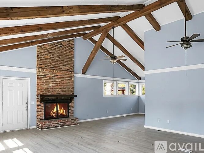 A room with a fireplace and a ceiling fan.
