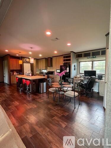 A kitchen with a dining table and chairs in the middle of the room.
