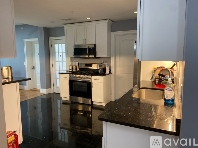 A kitchen with black countertops and white cabinets.