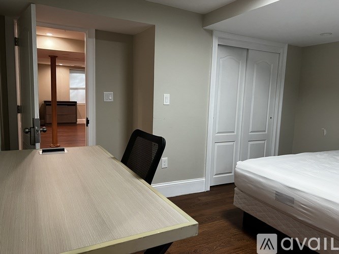 A room with a bed, a desk, and a chair.