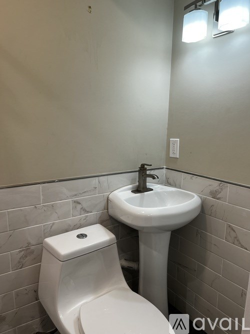 A white toilet and sink in a bathroom.
