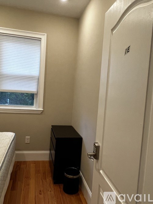 A black filing cabinet sits next to a white door.