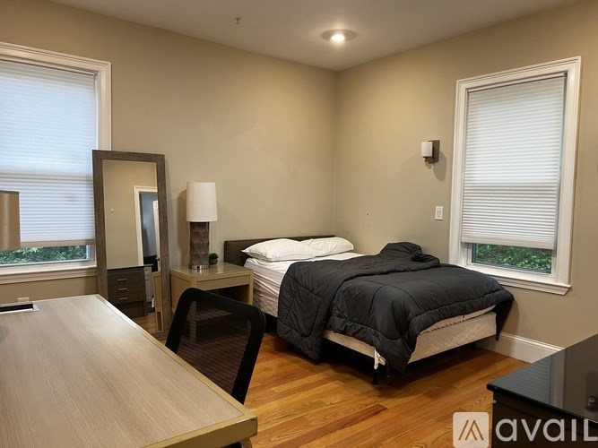 A bedroom with a bed, desk, and chair.