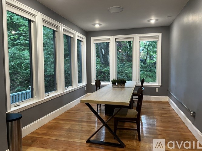 A dining room with a table and chairs and a balcony with a railing.