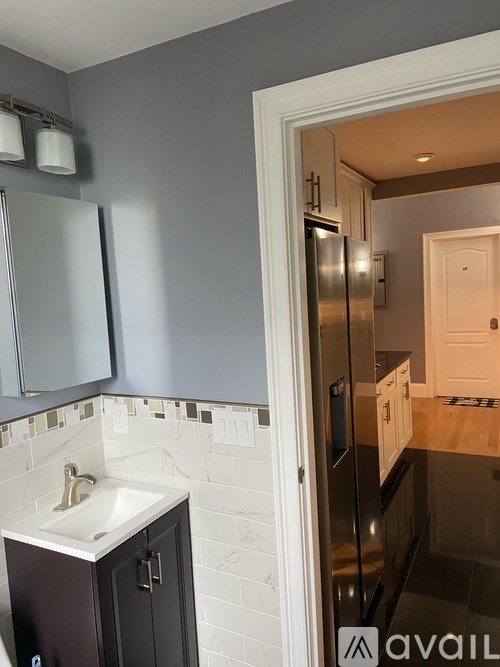 A kitchen with a white sink and a refrigerator.