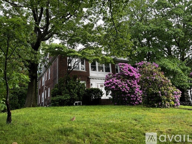 A large house with a lawn and trees in front.