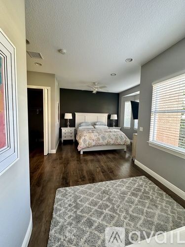A bedroom with a large bed and a rug in the foreground.