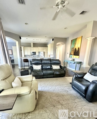A living room with a black and white leather couch and a white couch.