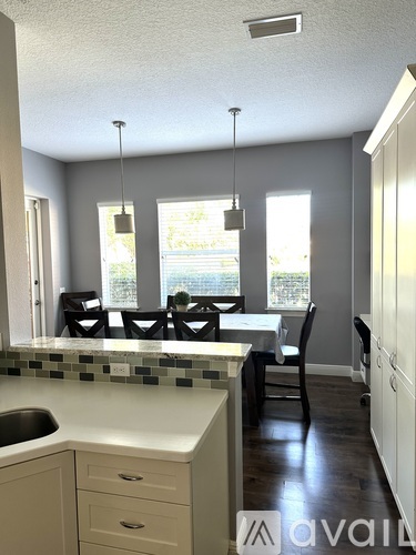 A kitchen with a table and chairs.