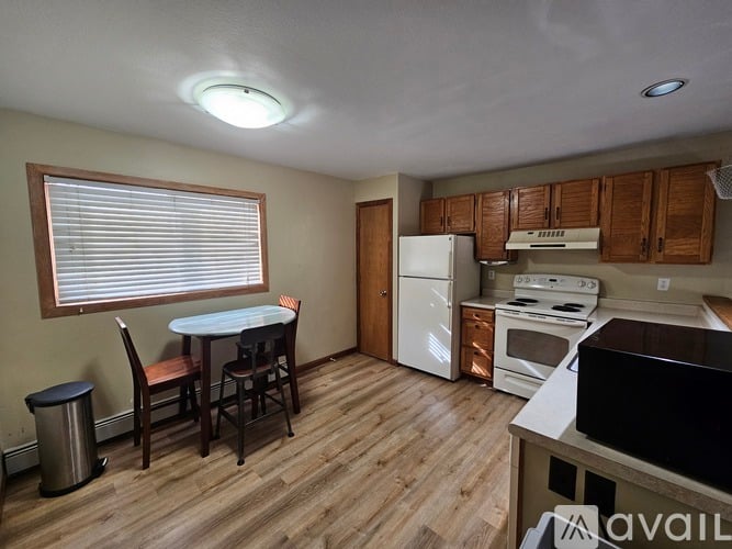 A kitchen with a white refrigerator, oven, and stove.