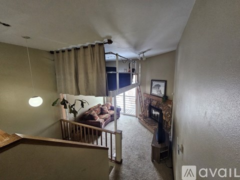 A living room with a couch and a window with curtains.