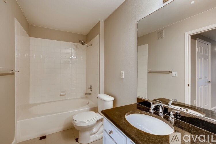 A bathroom with a white toilet, sink, and bathtub.