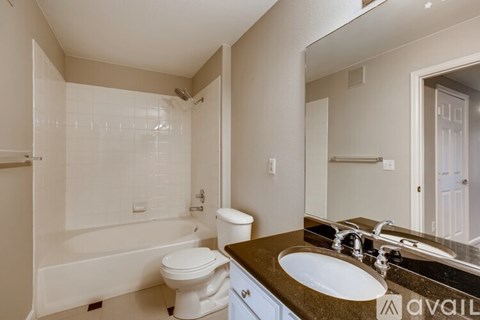 A bathroom with a white toilet, sink, and bathtub.