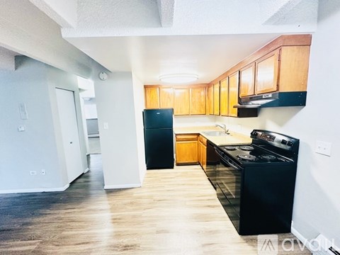 A kitchen with a black stove top oven and wooden cabinets.