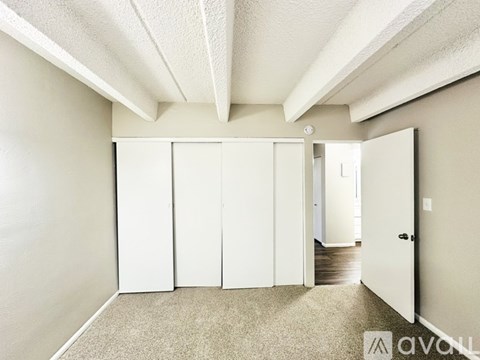 A room with white doors and carpeted floor.