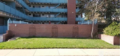 A brick wall with three windows in the middle.