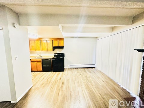 A room with wooden flooring and a white wall.
