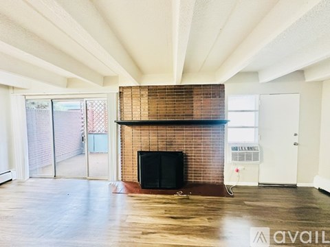 A living room with a brick fireplace and a television.