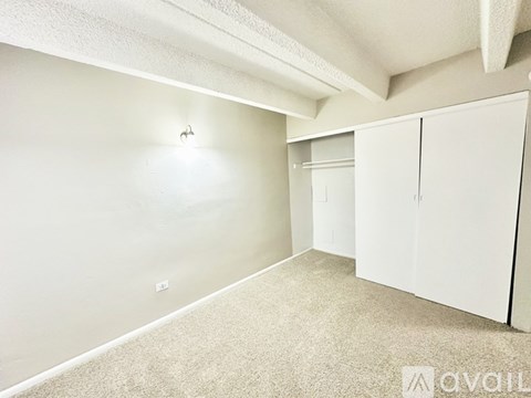 A room with white walls and carpeted floor with a white cabinet.