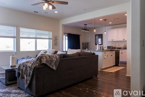 A modern living room with a dark brown couch and a ceiling fan.