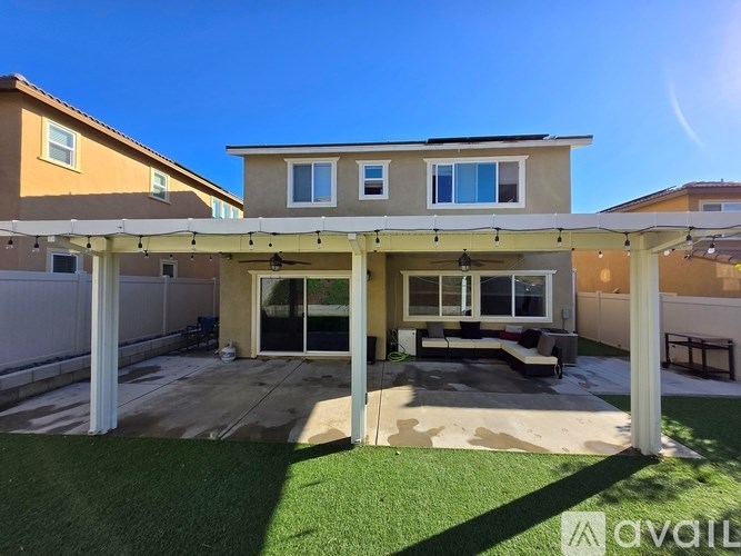 A house with a covered patio and a lawn.