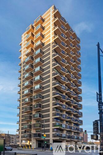 A tall apartment building with balconies on each floor.