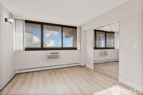 A spacious room with a large window and a sliding glass door.