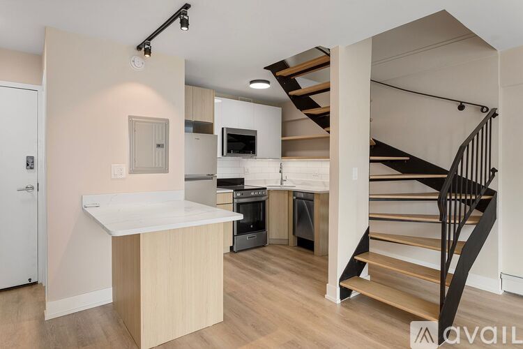 A kitchen with a staircase leading to the upper floor.