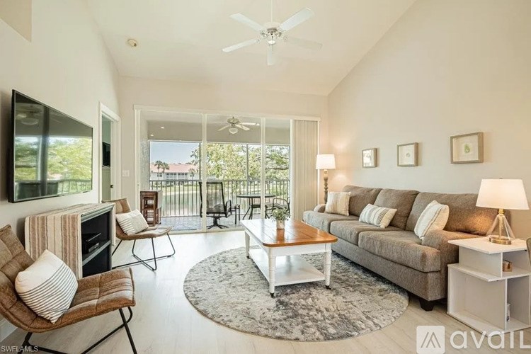 A living room with a couch, chairs, and a television.