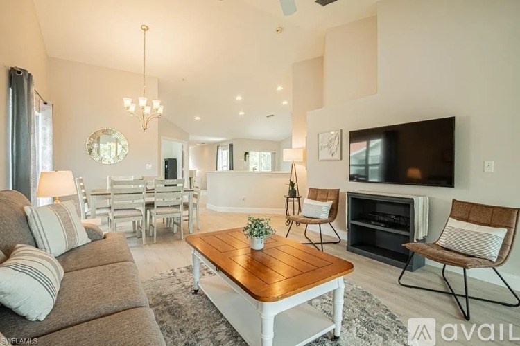 A living room with a grey couch, a wooden coffee table, and a television.