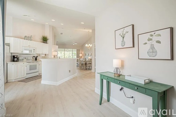 A kitchen with a green table and white walls.