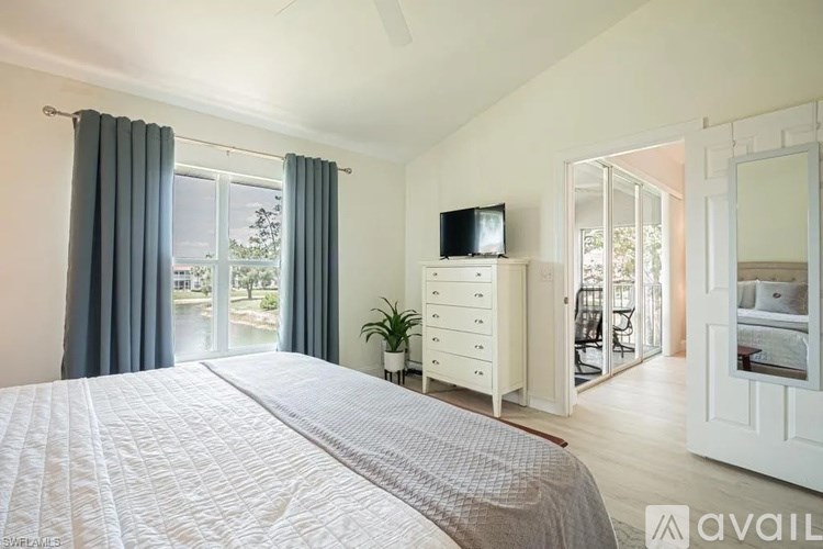 A bedroom with a large bed and a television on the dresser.