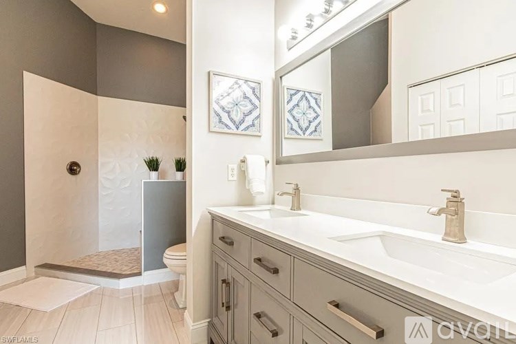 A bathroom with a white sink, a mirror, and a toilet.