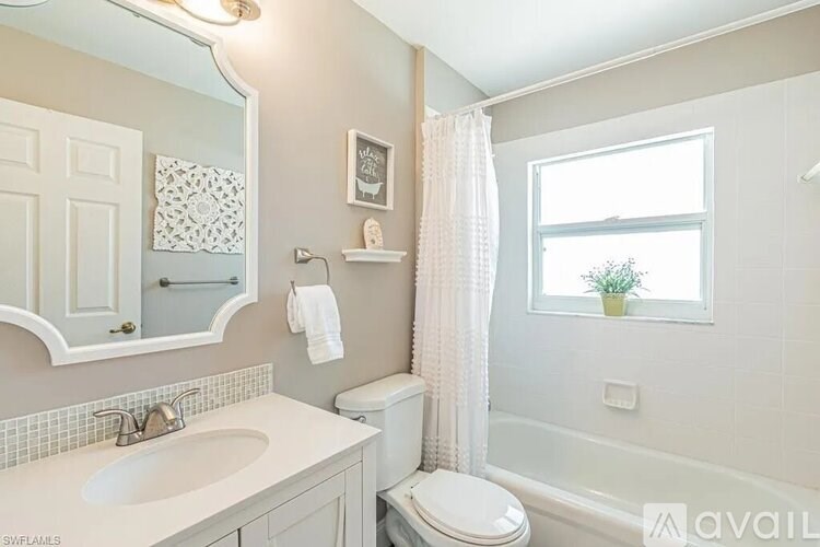 A bathroom with a toilet, sink, and bathtub.