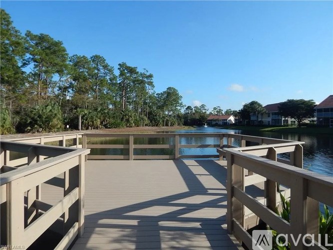 A wooden walkway over a body of water with trees in the background.