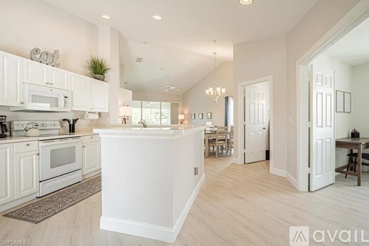 A modern kitchen with white cabinets and a large island.
