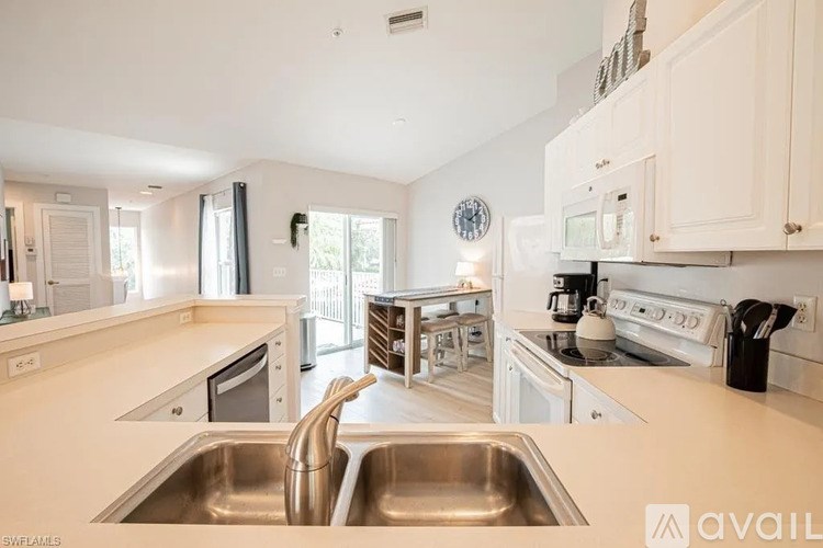 A modern kitchen with white cabinets and stainless steel appliances.