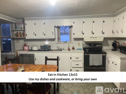 A kitchen with white cabinets and a wooden table.
