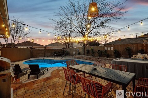 A backyard with a pool and a table set for dining.