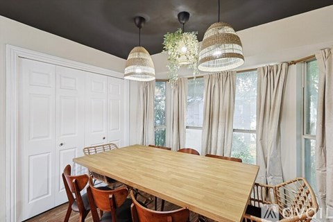 A dining room with a wooden table and chairs.