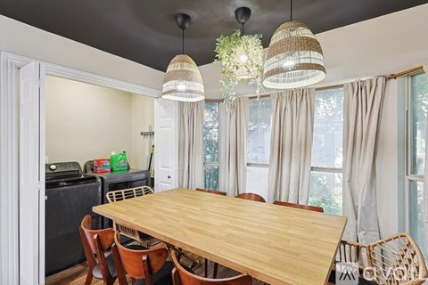 A kitchen with a table and chairs.