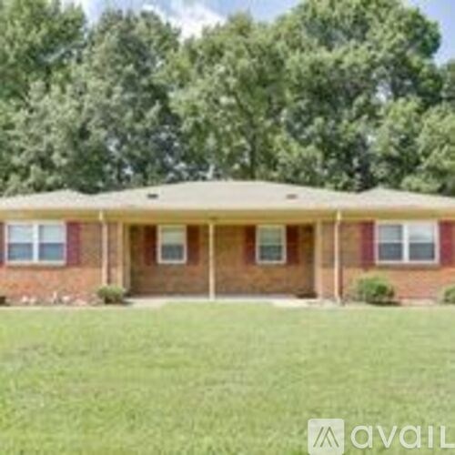 A house with a red brick exterior and a covered porch.