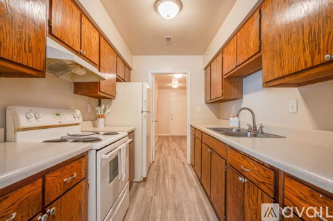 A kitchen with wooden cabinets and white appliances.