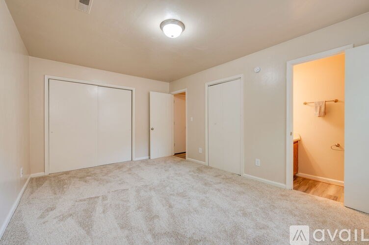 A spacious room with a carpeted floor and white walls.